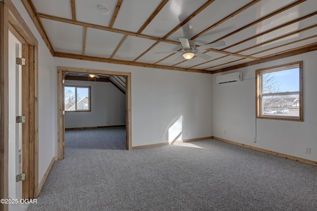 spare room featuring carpet floors, an AC wall unit, ceiling fan, and baseboards