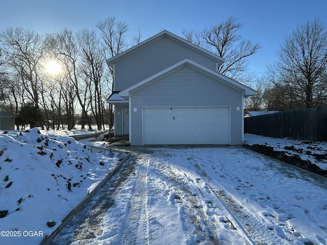 snow covered garage with fence