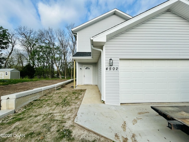 view of side of home featuring a garage and driveway