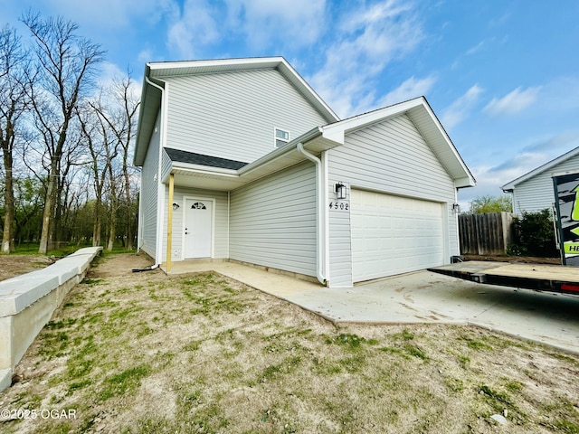 view of side of home with a garage and fence
