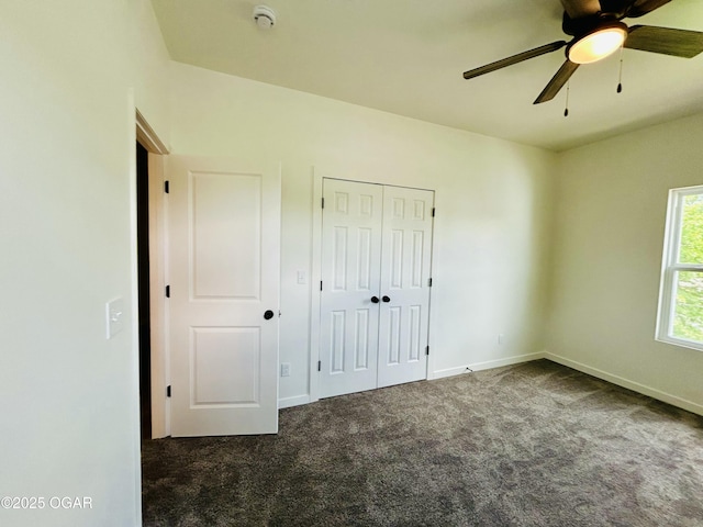 unfurnished bedroom featuring carpet flooring, a closet, baseboards, and ceiling fan