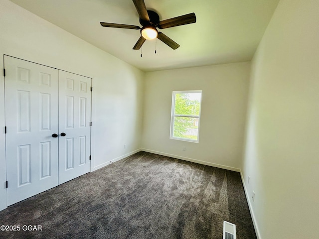 unfurnished bedroom featuring a closet, visible vents, ceiling fan, carpet flooring, and baseboards