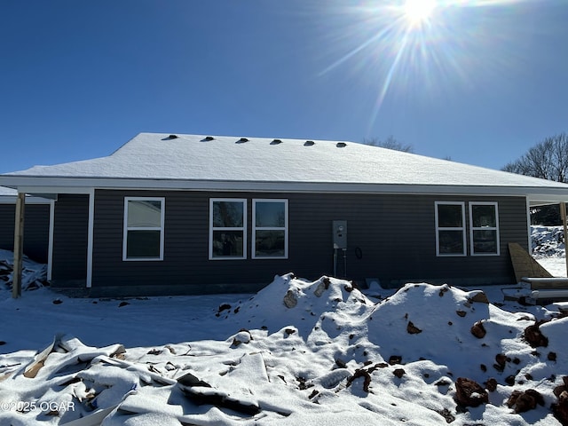 view of snow covered rear of property