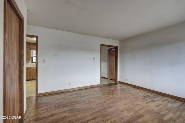 unfurnished room featuring wood finished floors and baseboards