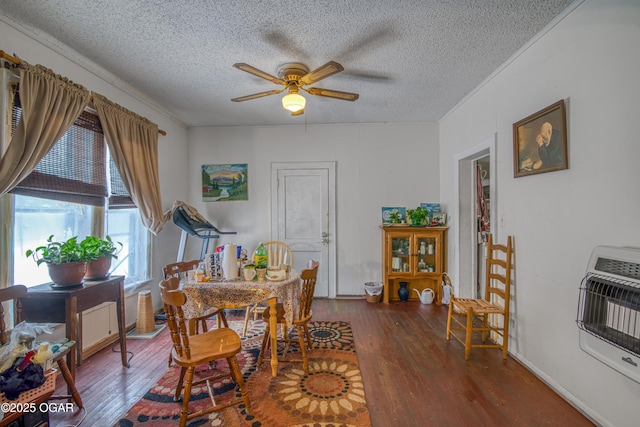 dining area featuring heating unit, dark wood-style floors, ceiling fan, and a textured ceiling