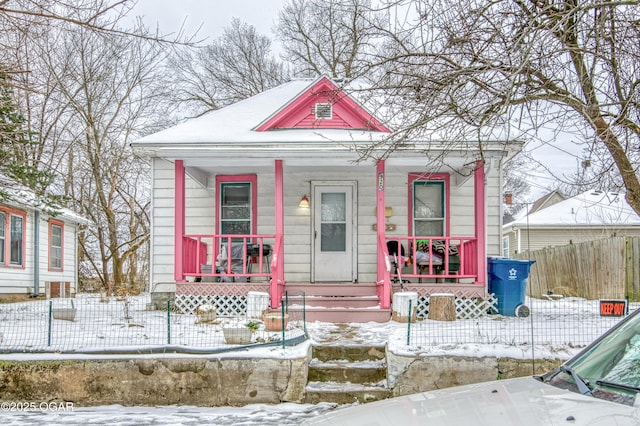 view of front facade featuring a porch and fence