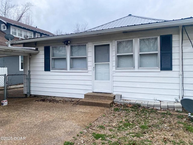 entrance to property with metal roof and fence