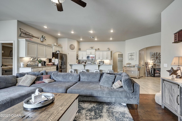 living room with visible vents, arched walkways, ceiling fan, light wood-style flooring, and recessed lighting