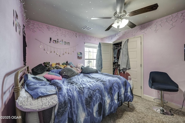 carpeted bedroom featuring baseboards, a closet, visible vents, and a ceiling fan