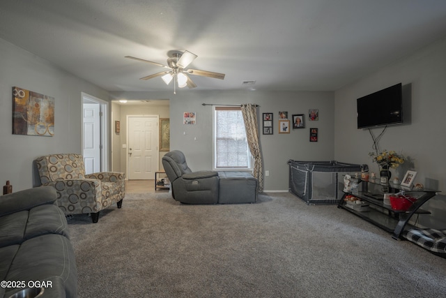 living area featuring visible vents, a ceiling fan, and carpet