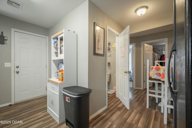 entryway featuring visible vents, baseboards, and wood finished floors