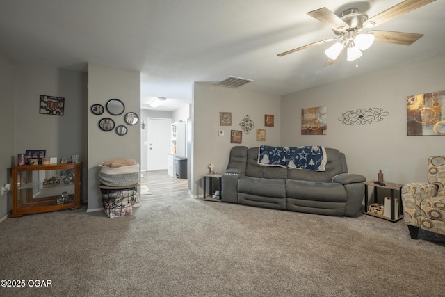 carpeted living area with visible vents and ceiling fan