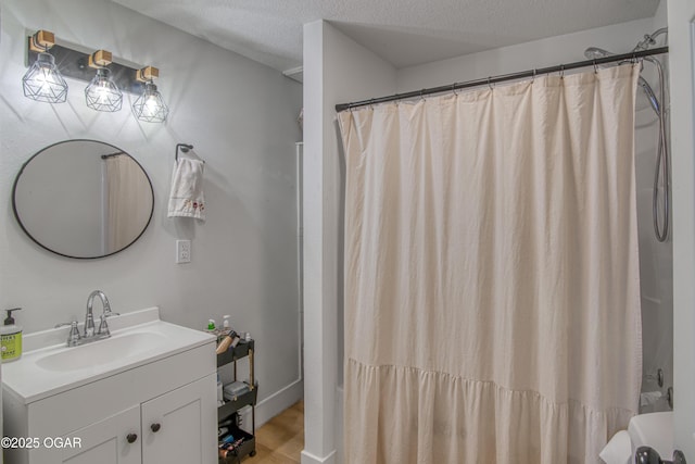 bathroom with shower / bath combo, a textured ceiling, vanity, and wood finished floors