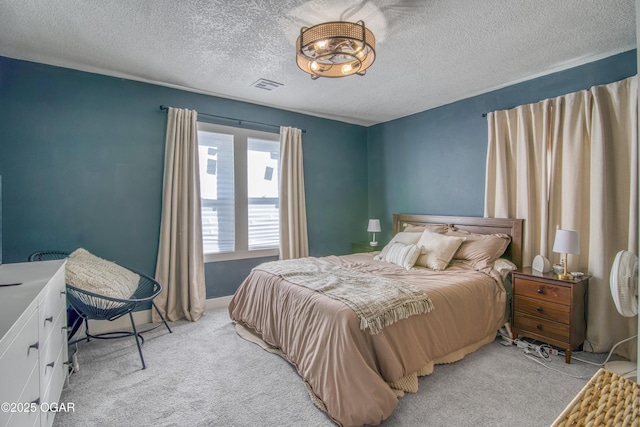 bedroom featuring visible vents, light carpet, and a textured ceiling