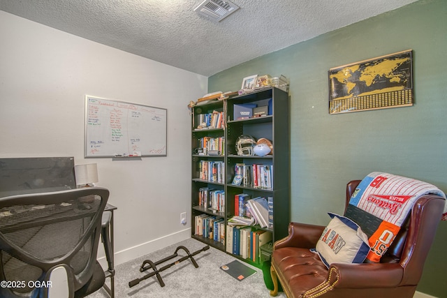 office space featuring carpet, visible vents, a textured ceiling, and baseboards