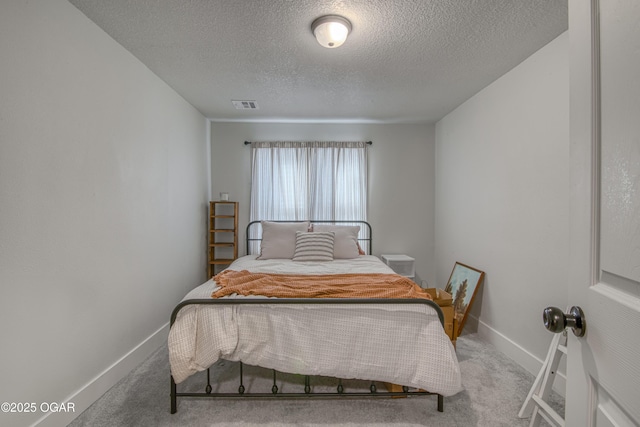 bedroom with light carpet, baseboards, visible vents, and a textured ceiling