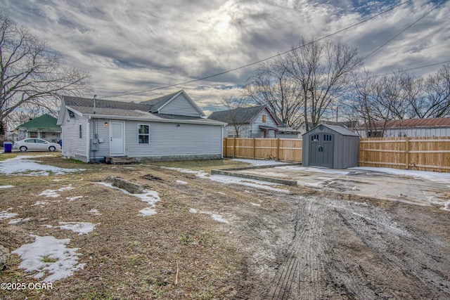 exterior space featuring an outbuilding, a storage unit, and fence