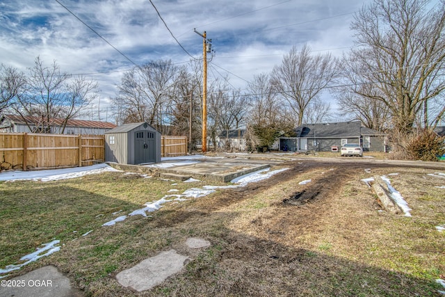 view of yard with a storage shed, fence, and an outbuilding