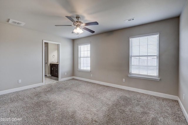 spare room with light carpet, baseboards, and visible vents