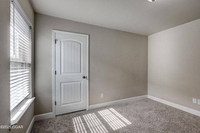 carpeted empty room with baseboards