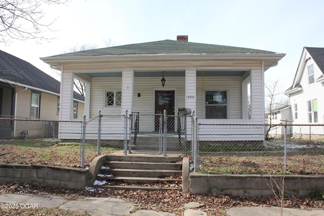 view of front of property featuring a porch, a fenced front yard, a shingled roof, a gate, and a chimney