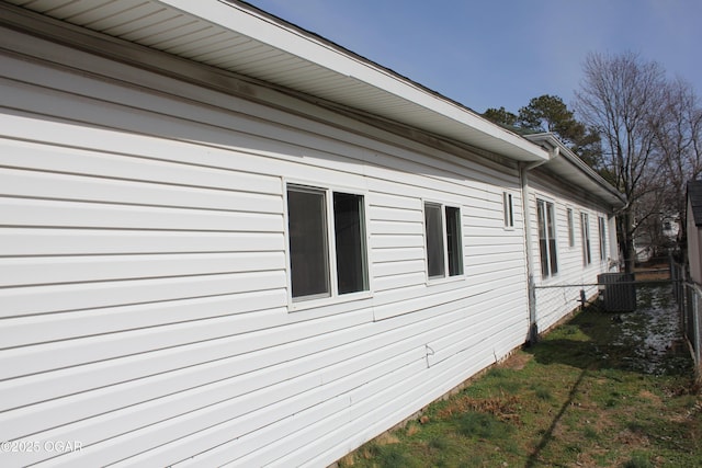 view of home's exterior featuring central air condition unit and fence