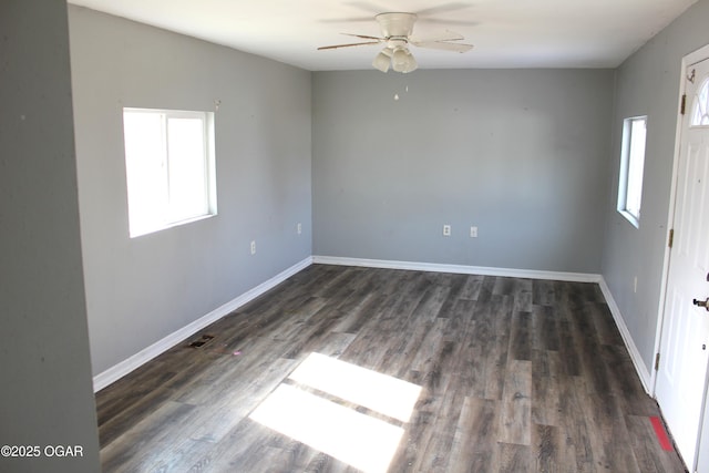 unfurnished room with dark wood-style floors, a wealth of natural light, and baseboards