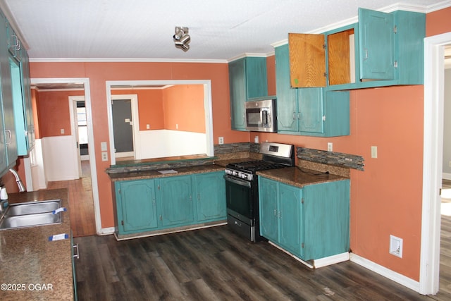 kitchen featuring baseboards, appliances with stainless steel finishes, ornamental molding, dark wood-type flooring, and a sink