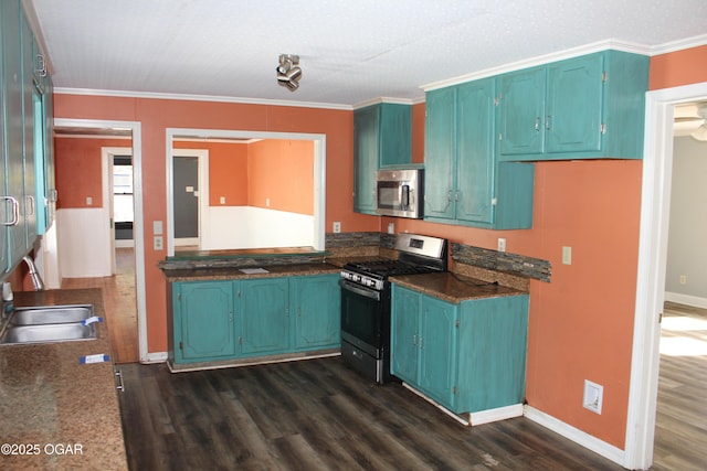 kitchen featuring appliances with stainless steel finishes, dark wood-style flooring, crown molding, and a sink