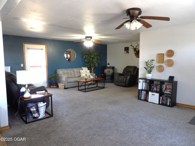 carpeted living room with a ceiling fan and baseboards