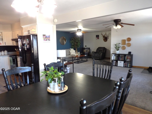 carpeted dining room with baseboards and a ceiling fan