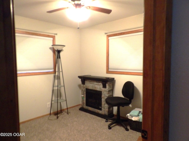 living area with carpet, ceiling fan, a fireplace, and baseboards