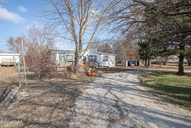 manufactured / mobile home featuring a deck and gravel driveway