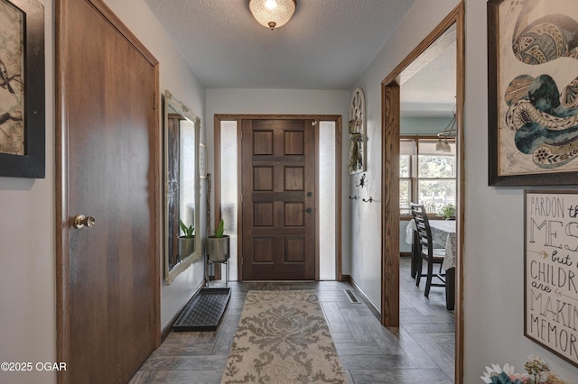 entryway featuring baseboards and a textured ceiling