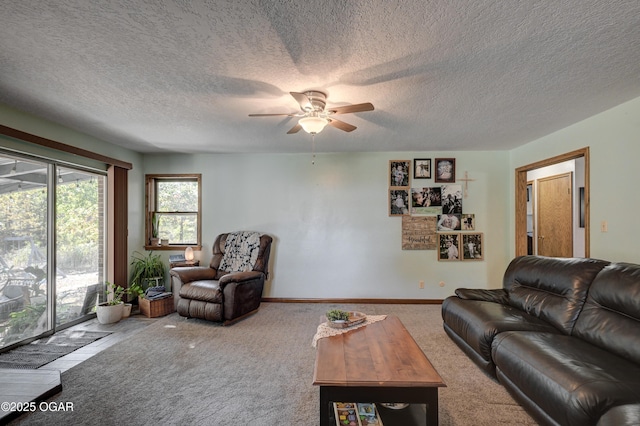 living room with carpet, baseboards, ceiling fan, and a textured ceiling