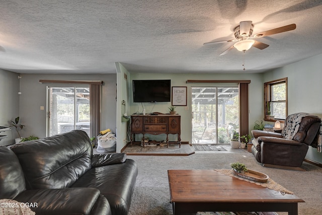 living room with a wealth of natural light, carpet flooring, and a textured ceiling