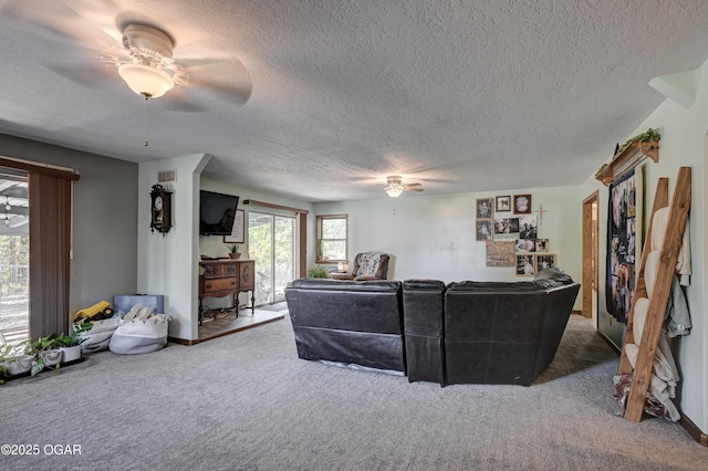 carpeted living room featuring ceiling fan and a textured ceiling