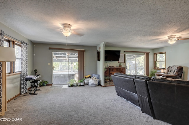 carpeted living room with a ceiling fan, a wealth of natural light, and baseboards