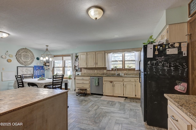 kitchen with a wealth of natural light, freestanding refrigerator, dishwasher, and a sink