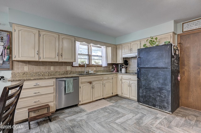 kitchen with tasteful backsplash, freestanding refrigerator, a sink, light stone countertops, and dishwasher