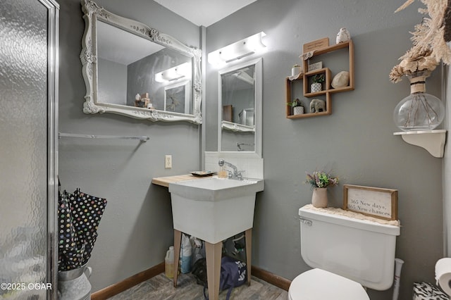 bathroom with toilet and baseboards