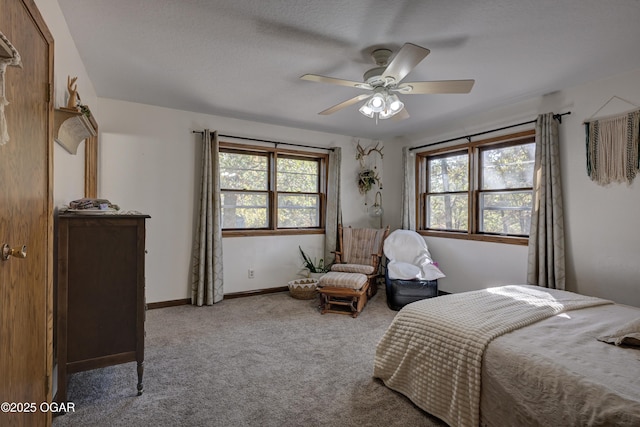 bedroom featuring multiple windows, carpet flooring, a ceiling fan, and baseboards