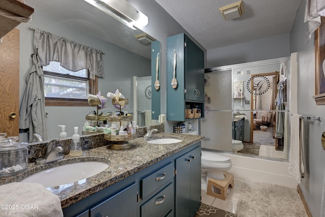 bathroom featuring a textured ceiling, an enclosed shower, a sink, and toilet