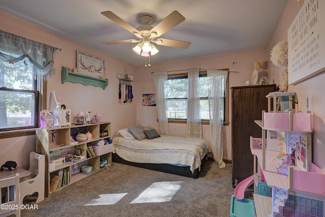 bedroom featuring carpet floors, ceiling fan, and multiple windows