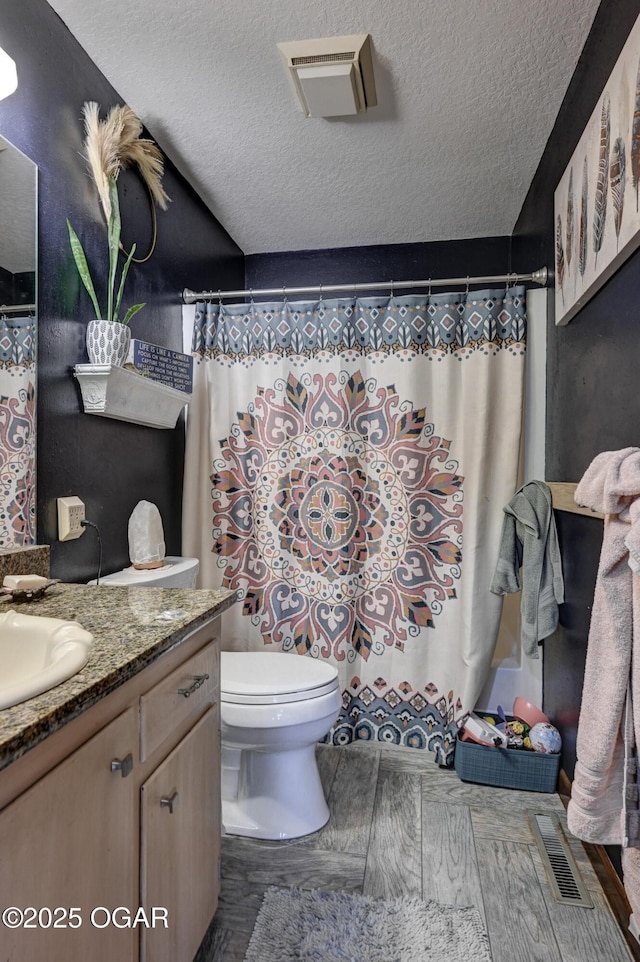 full bathroom featuring visible vents, a textured ceiling, and vanity