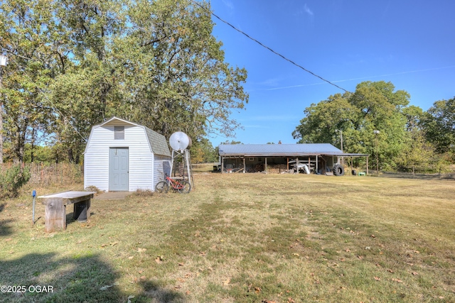 view of yard with a carport, an outdoor structure, and a shed