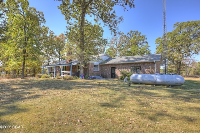 exterior space with brick siding and a yard