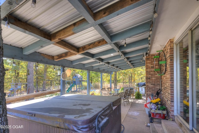 view of patio with a hot tub, outdoor dining area, and a playground