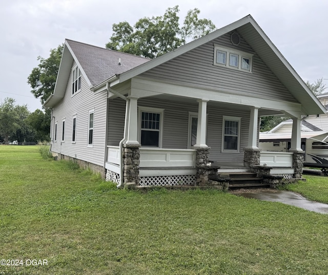 view of front of house featuring a porch, roof with shingles, and a front lawn