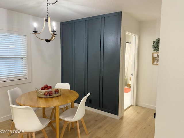 dining space with baseboards and light wood-style floors